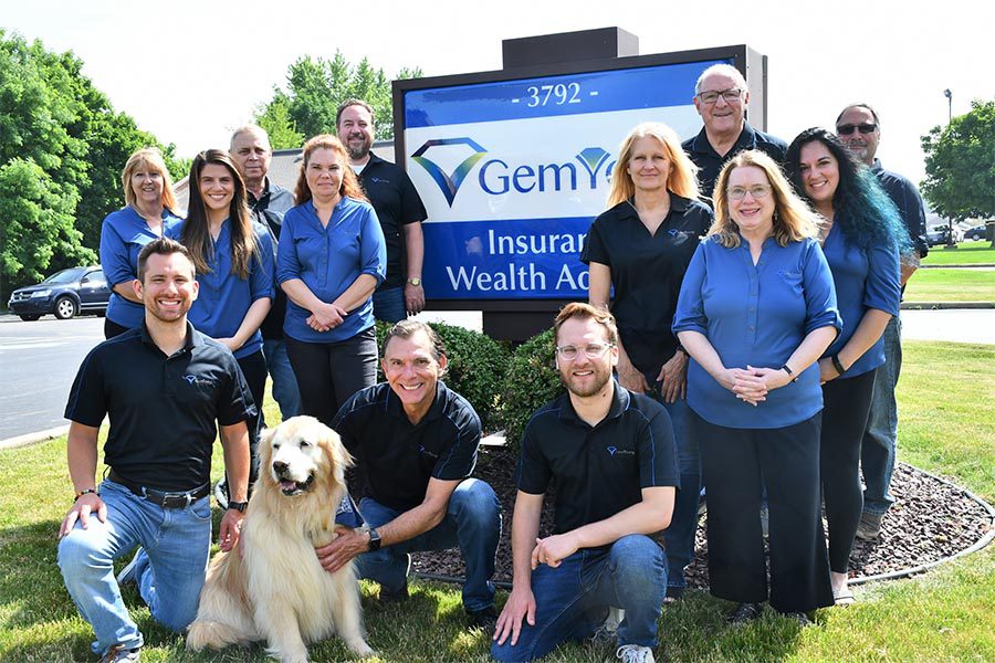 Gem-Young Insurance & Wealth Advisors - Group Photo of the Team Standing Outside in Front of a Side on a Nice Day and a Dog is with Them