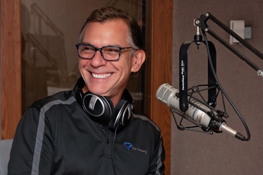 “Your Money” Radio Show - Man Speaking into Microphone While Sitting in a Studio While Recording a Radio Show